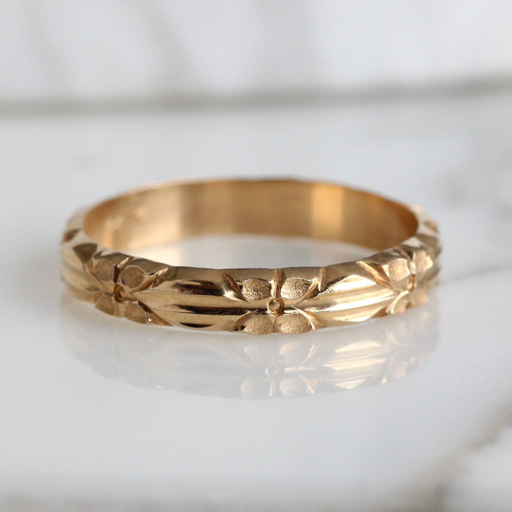 large size gold ring with an all around design of flowers