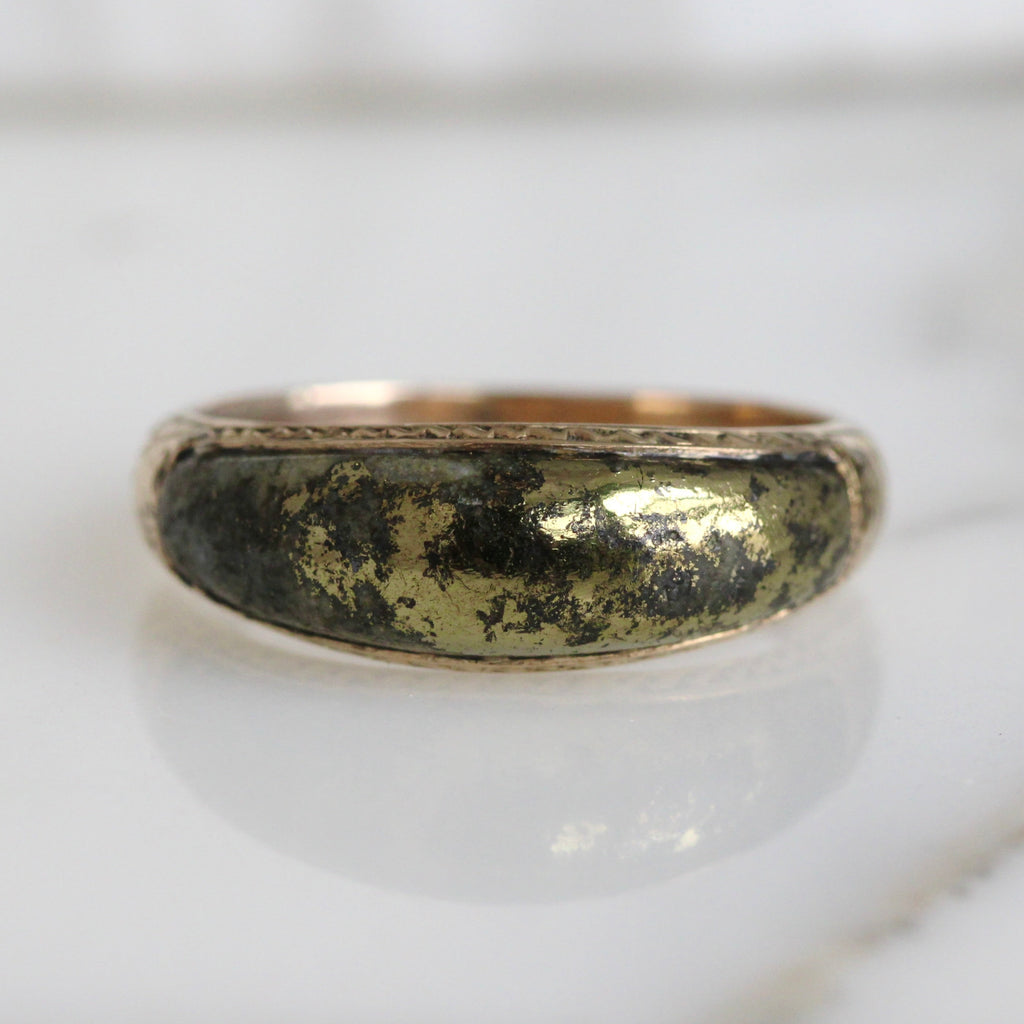 gold ring with a domed front set with a grey stone that has pure gold veins in it