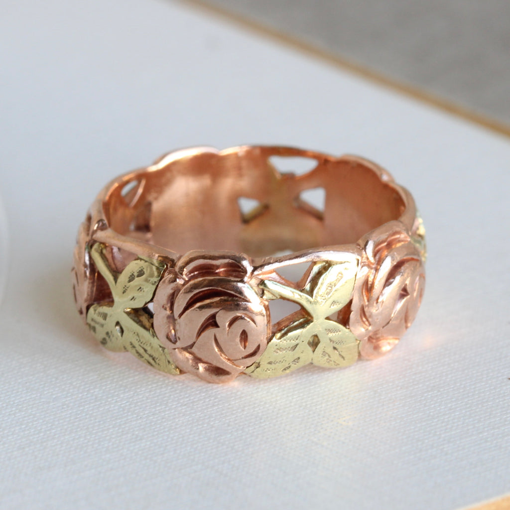 wide vintage band carved all around with roses and leaves, the roses in rose gold and the leaves in green gold