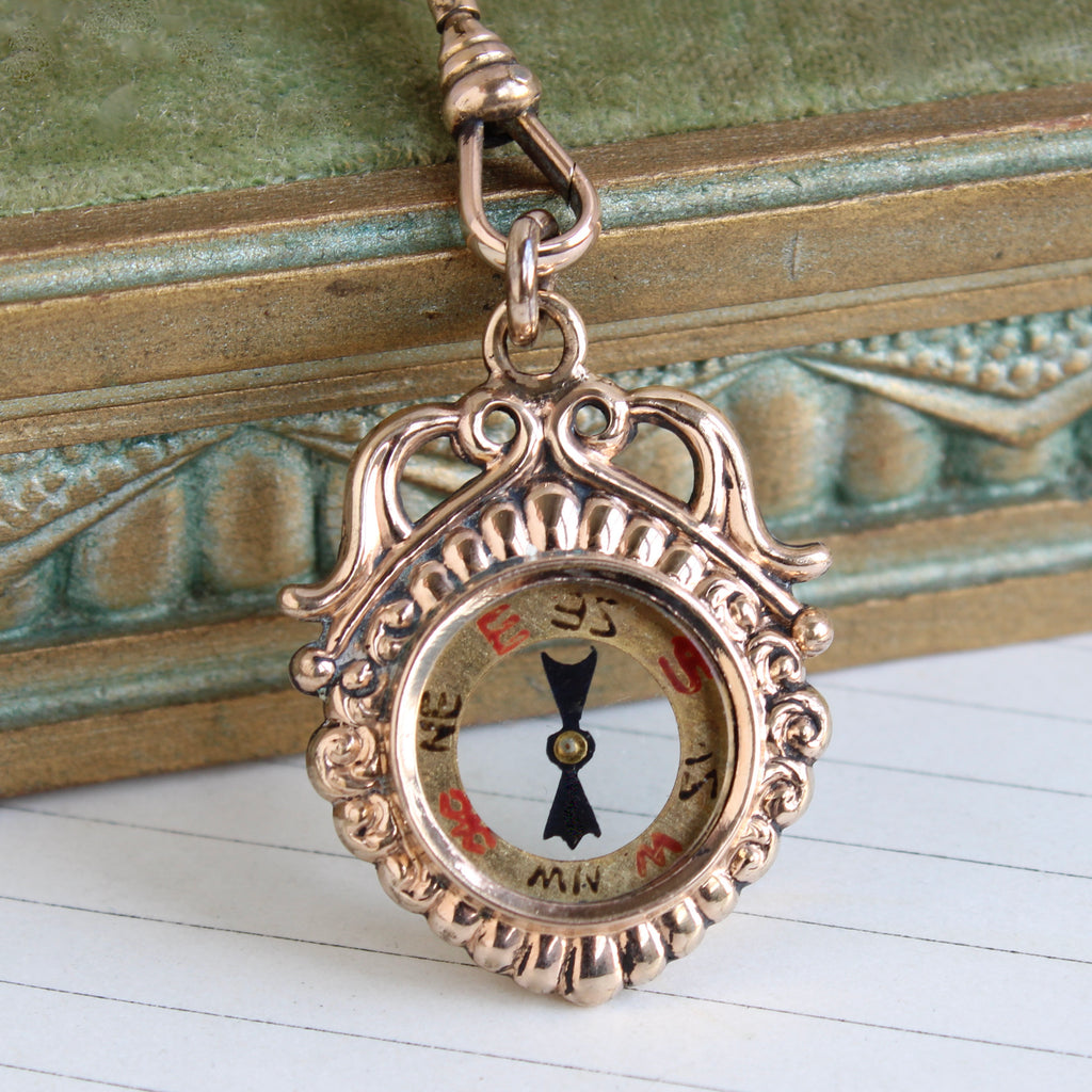 miniature compass pendant with rose gold case on a chain