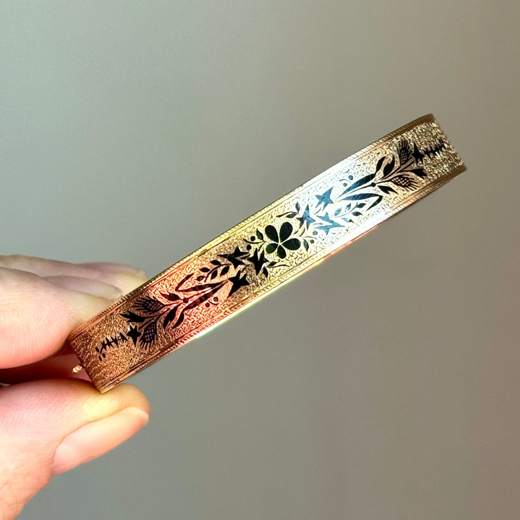 yellow gold bangle with black enamel floral designs