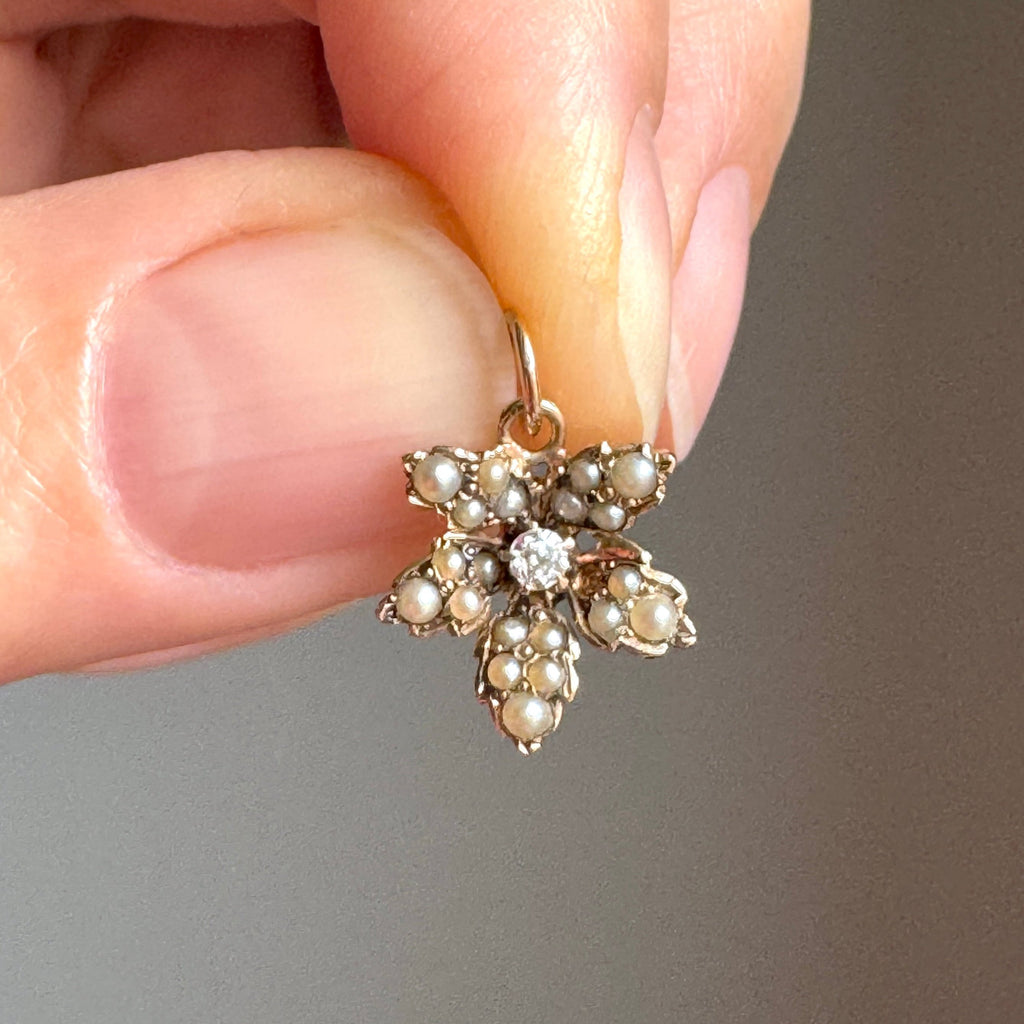 a miniature ivy leaf charm in yellow gold set all over with pearls and a dimaond in the center