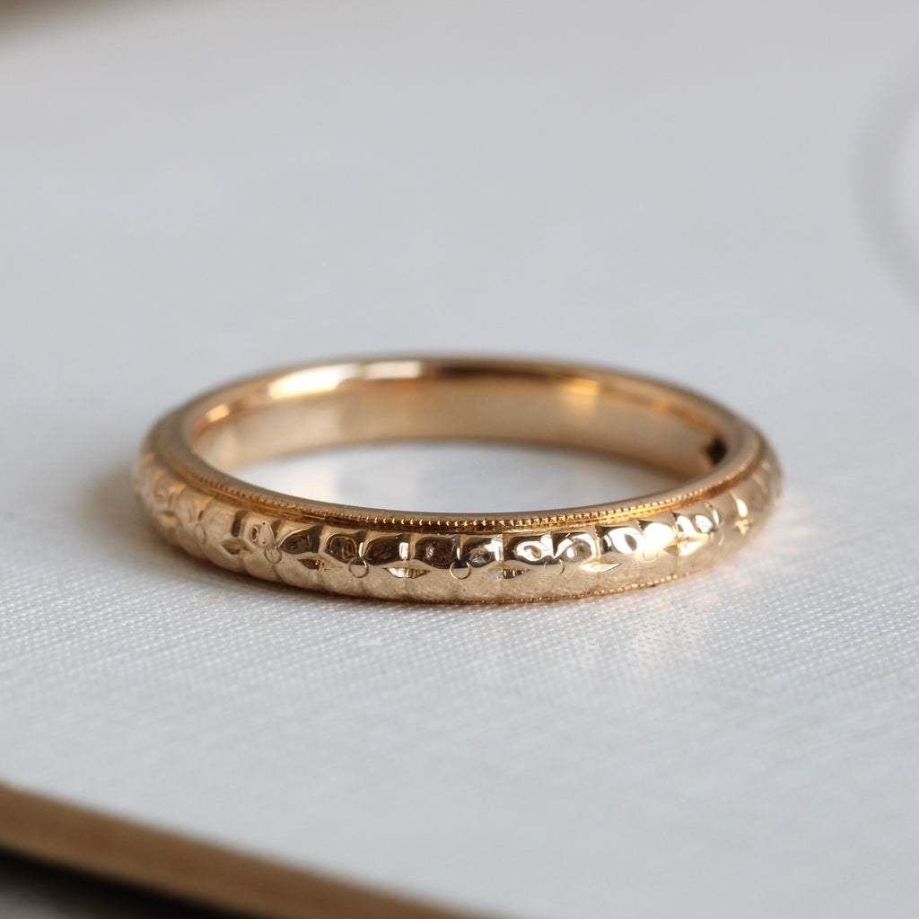 yellow gold band chased with a stylized orange blossom motif all around the outside
