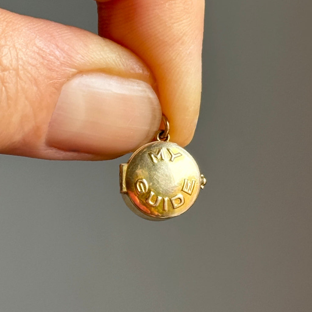 yellow gold miniature pillbox charm with the words my guide embossed on the lid.