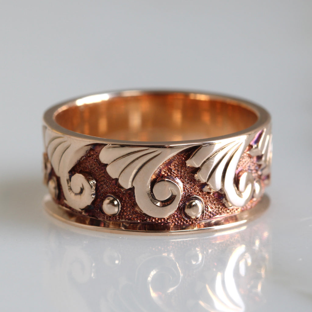 rose gold band with a scroll pattern all around the outside