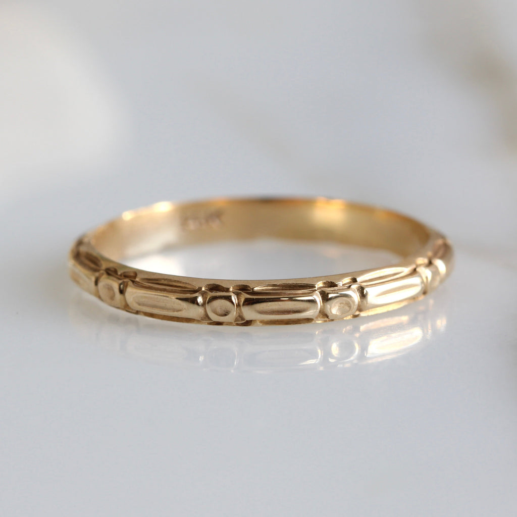yellow gold band with a continuous design of dots and dashes chased around the outside 