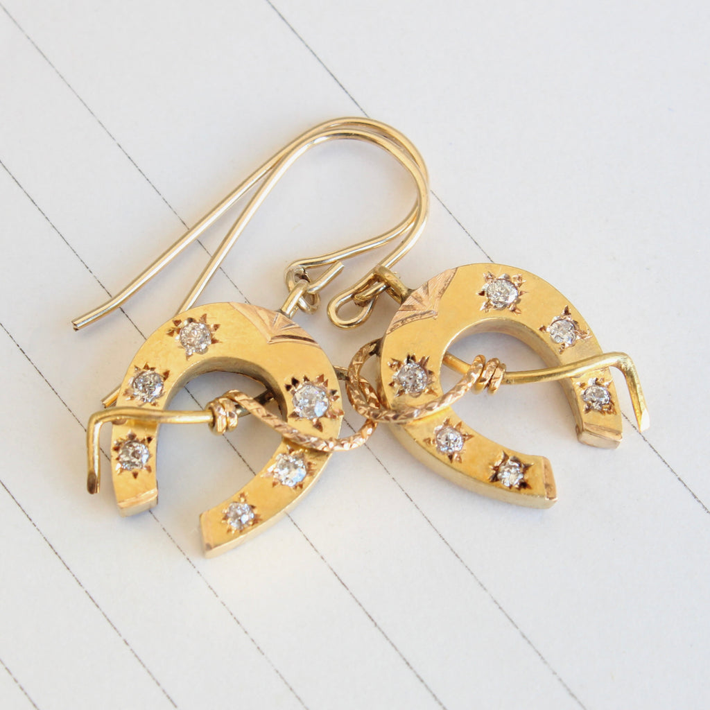 yellow gold horseshoe earrings set with old cut diamonds, dangling on ear wires 