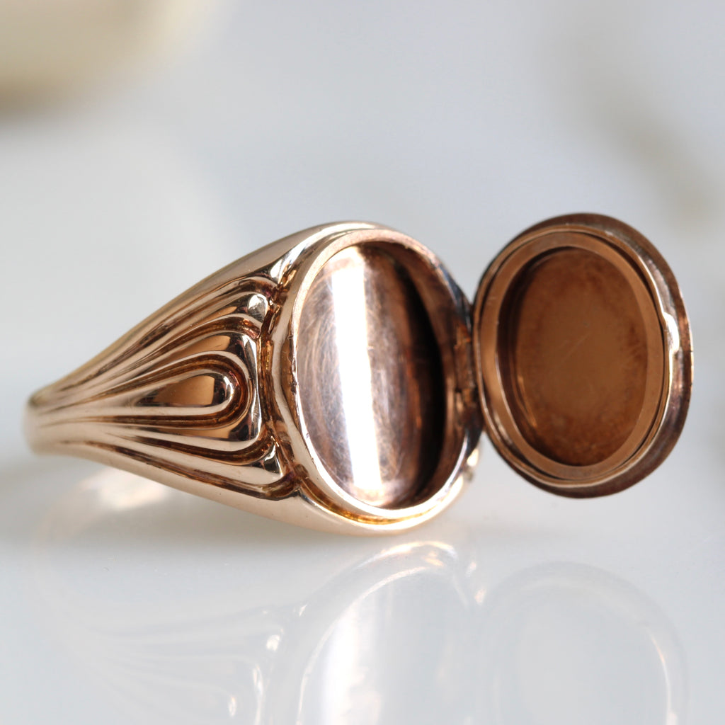 gold signet ring that has a locket hidden behind the face