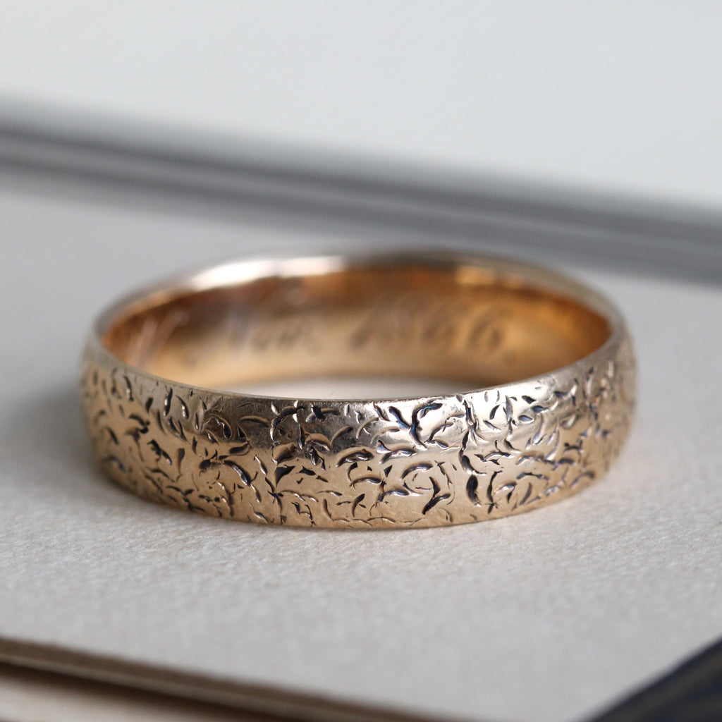 yellow gold band with a stylized floral engraving all around the outside, dated 1866 inside