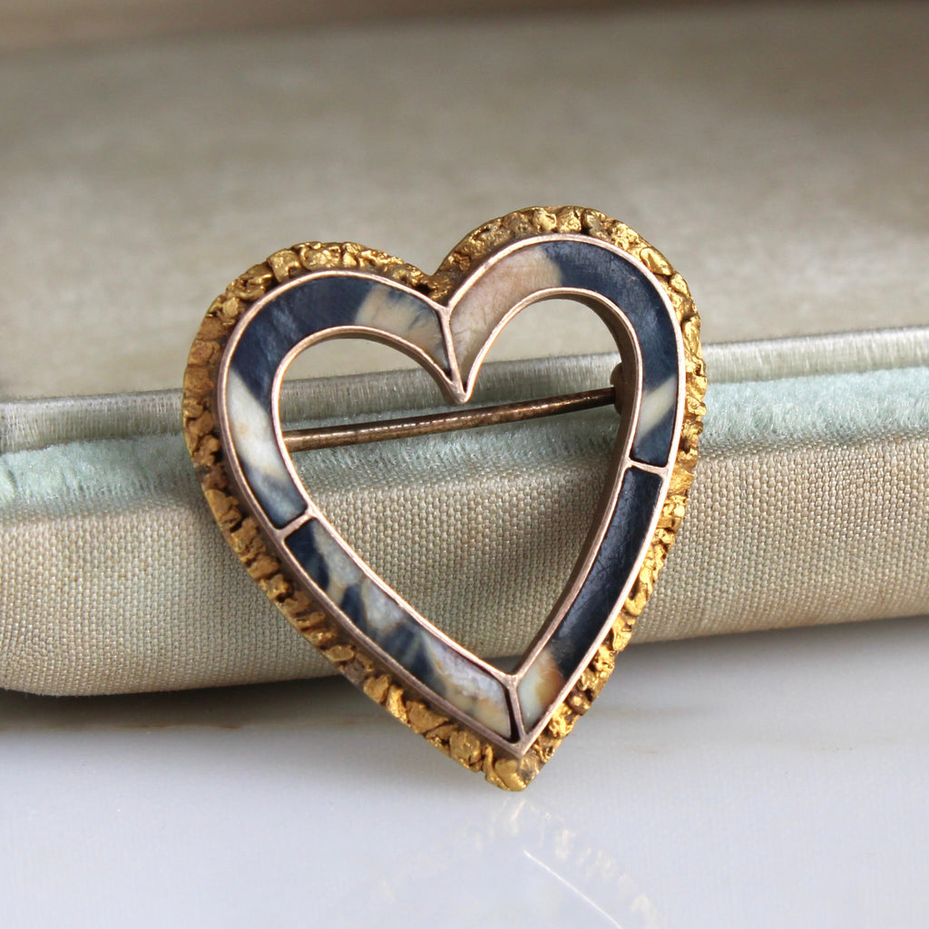 heart shaped brooch set with brown and cream striped quartz and a border of gold nuggets