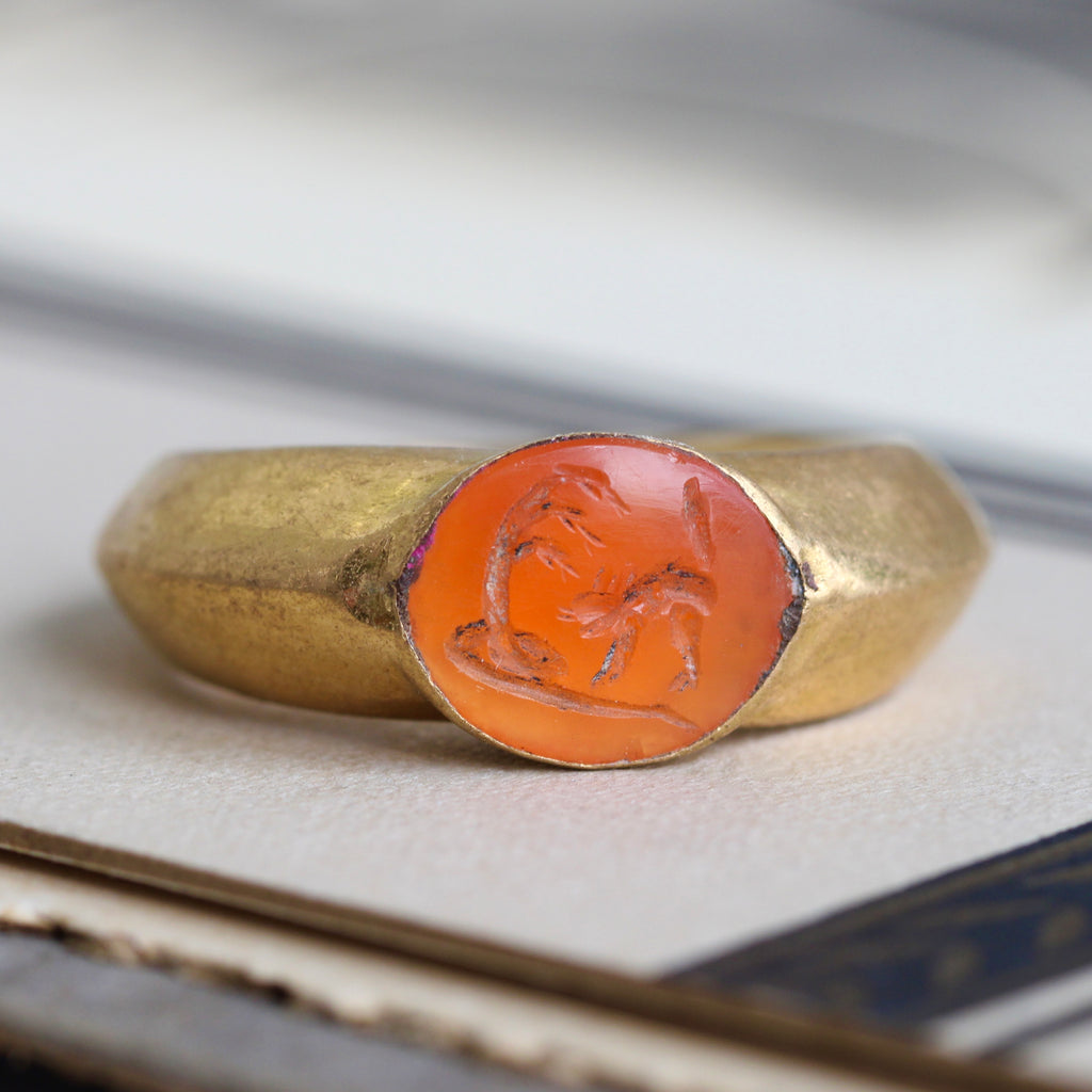 ancient high karat gold ring with carved stone inset showing three headed snake and hissing cat