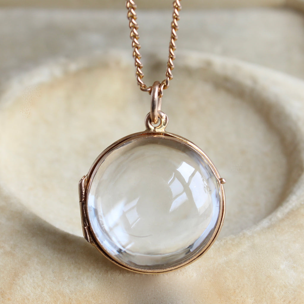 locket with rock crystal dome cabochon lids in a gold frame on a chain