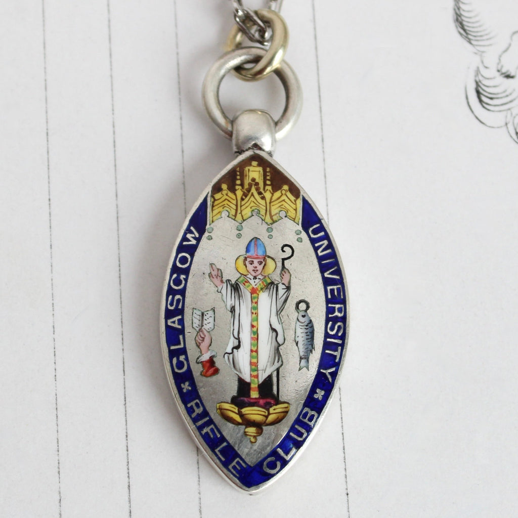 silver medal enameled with the figure of a bishop, with a fish and a hand holding an open book, reading Glasgow University rifle club