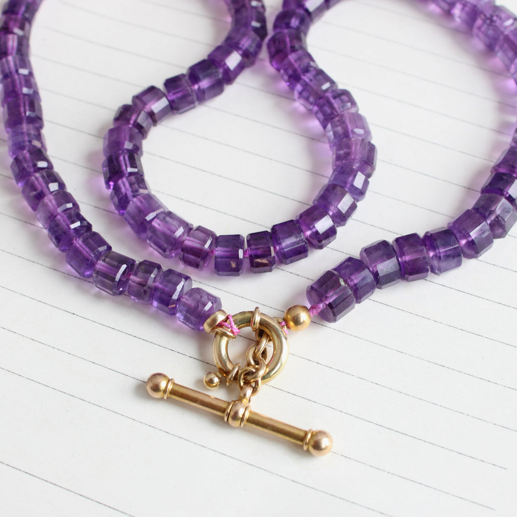 purple amethyst beads in a round faceted cut with a gold toggle clasp