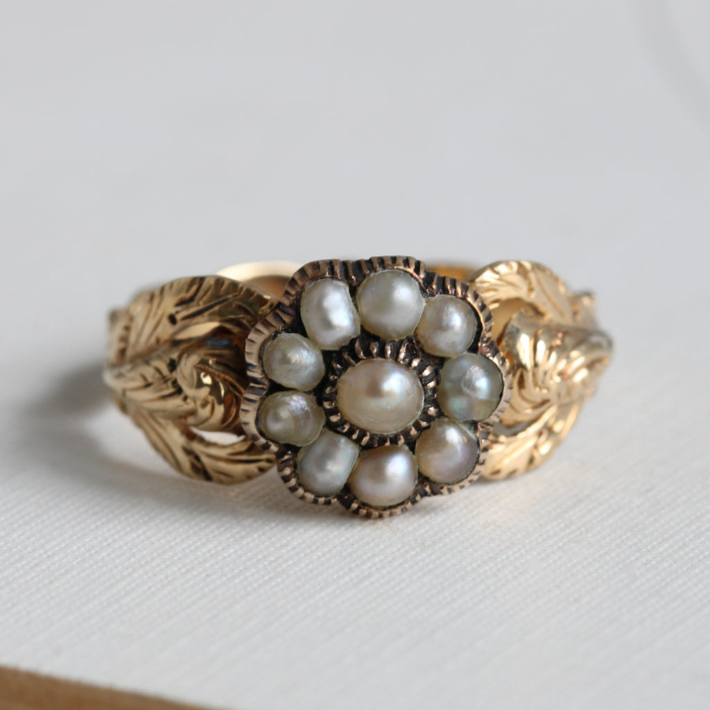 yellow gold ring with a flower motif pearl cluster and leaf design shoulders