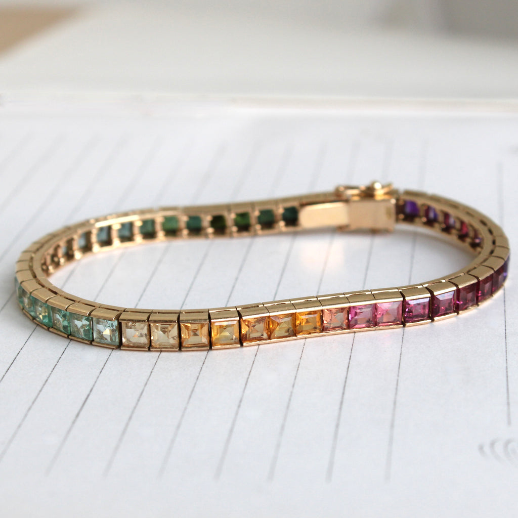 yellow gold tennis or line bracelet set with a rainbow range of colored gemstones