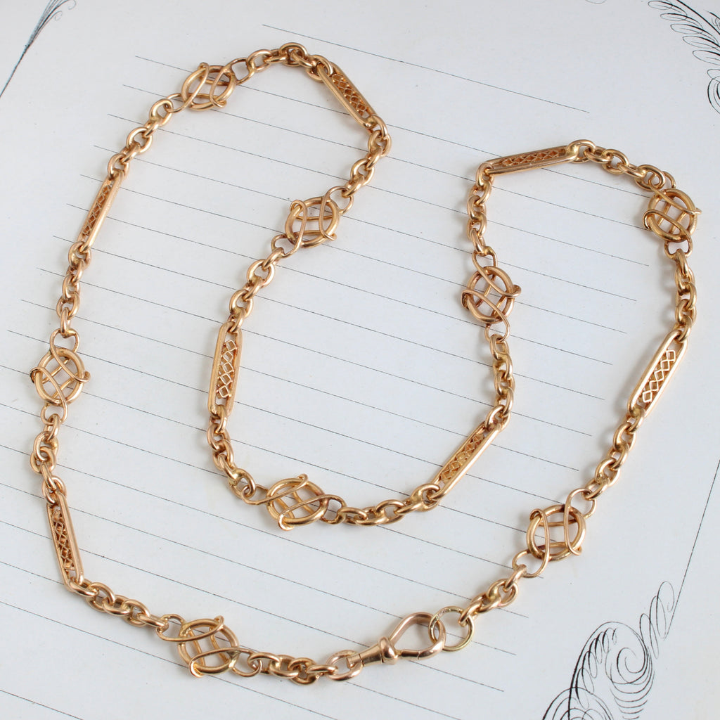 gold chain with 3 alternating styles of fancy links and a charm clip clasp