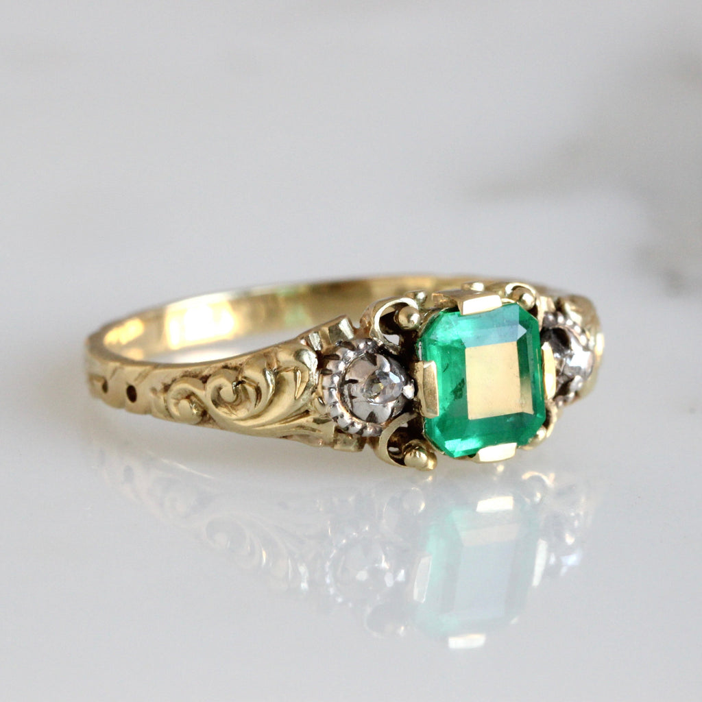 yellow gold ring set with square green gem with diamonds at each side