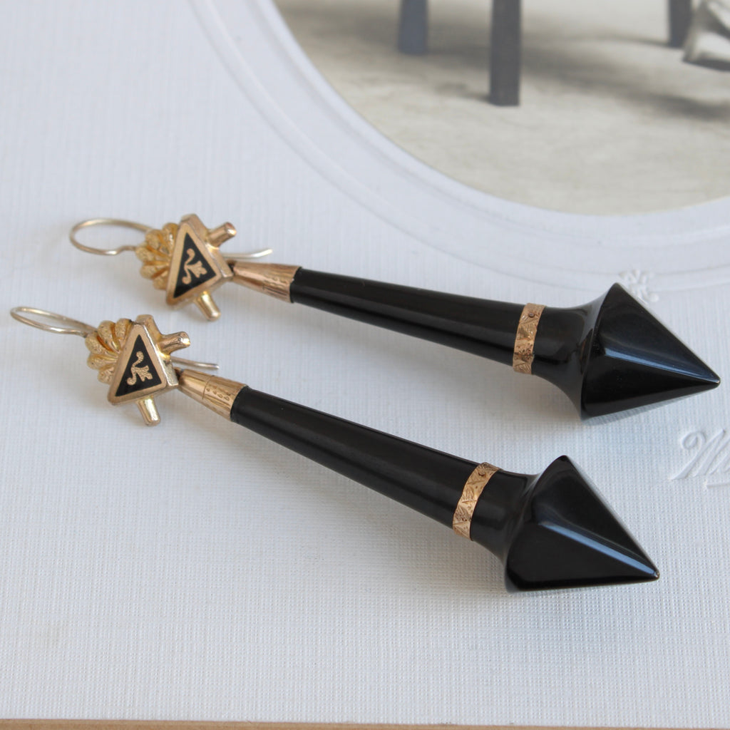 antique earrings with long arrow shaped carved black jet drops and gold tops that have black enamel decoration