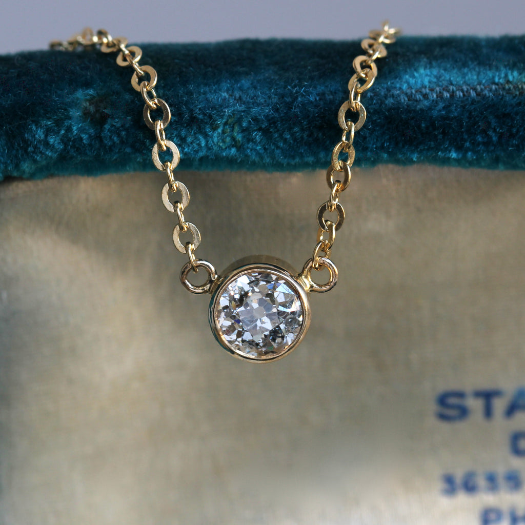 prismatic old mine cut diamond set in a yellow gold bezel on a chain