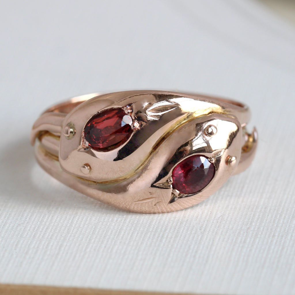 rose gold double headed snake ring with garnets set in the heads