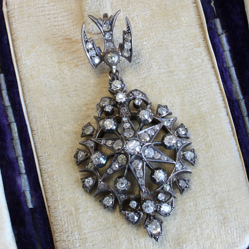 silver pendant with a dove decorating the bail at the top and a star shaped drop completely studded with diamonds