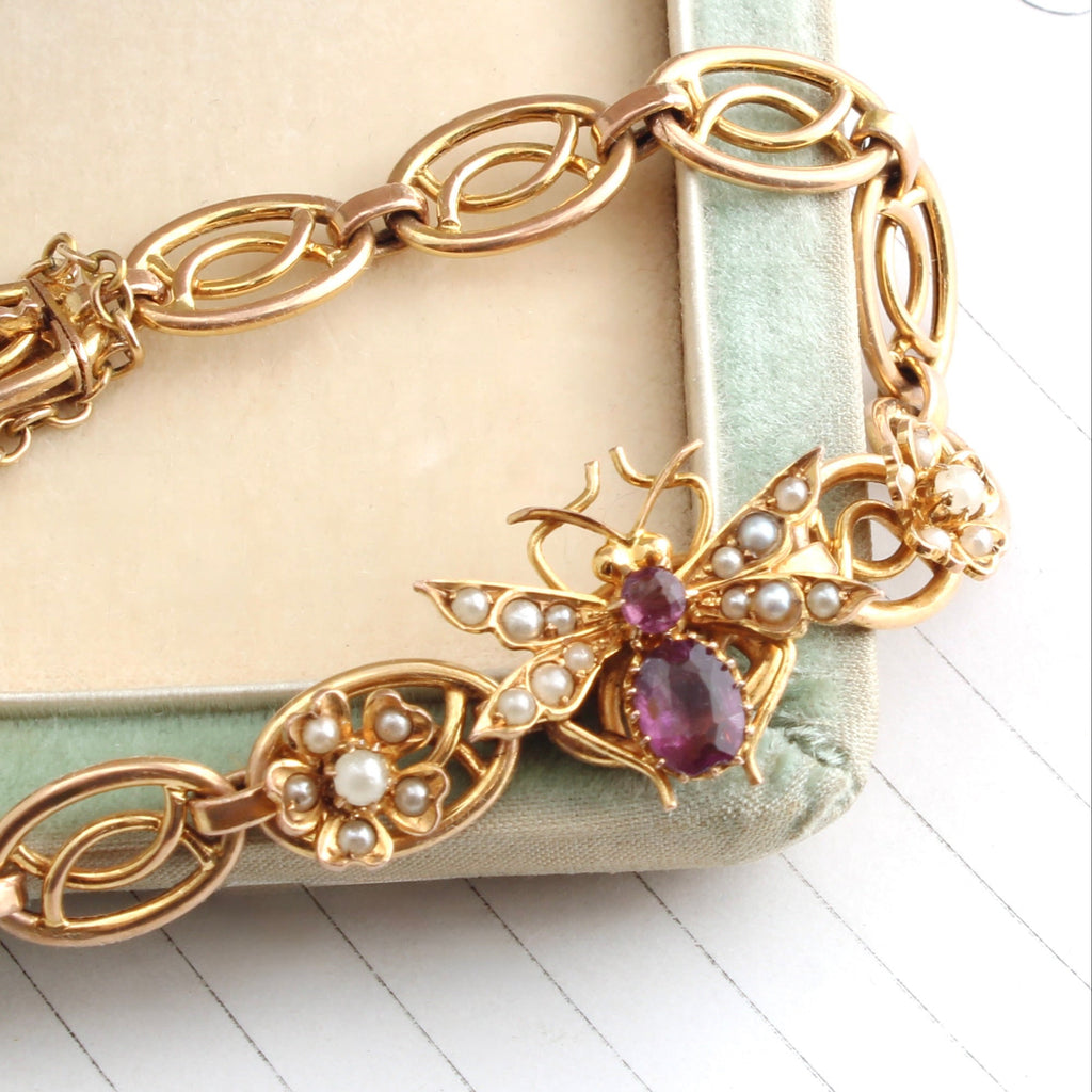 yellow gold bracelet with amethyst and pearl set bee between two flowers set with pearls