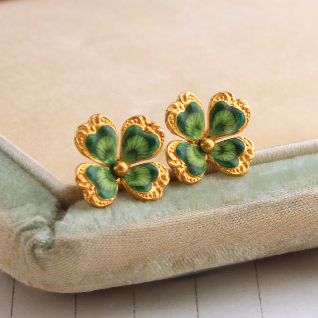 a pair of yellow gold stud earrings deisgned to look like four leaf clovers with realistic enamel 