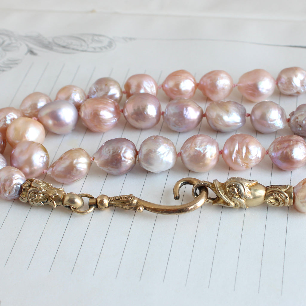 large pink and light purple tinted freshwater pearls with an antique gold hook clasp