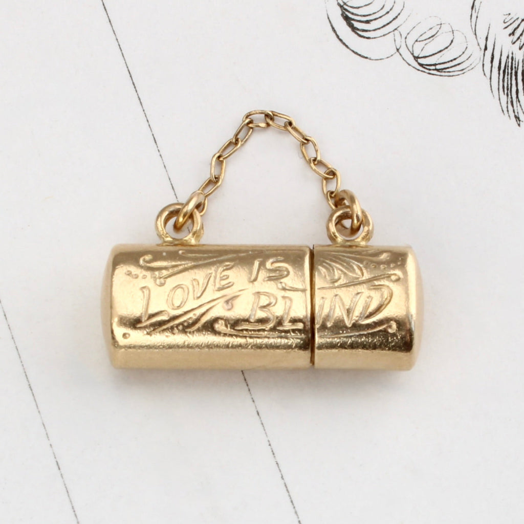 yellow gold eye glass case charm that holds a teeny pair of gold eye glasses