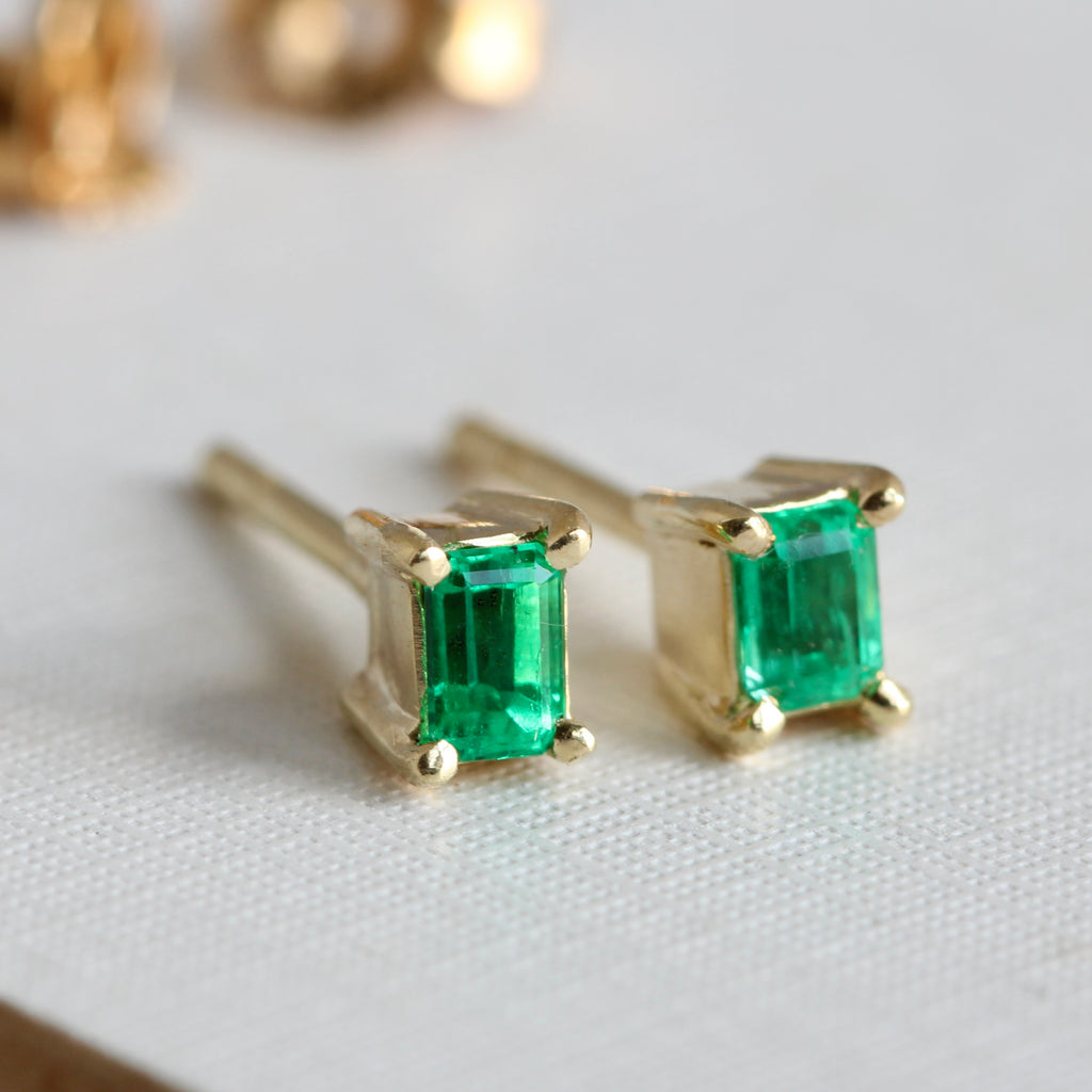 very bright rectangular green emeralds in yellow gold box stud earring mountings