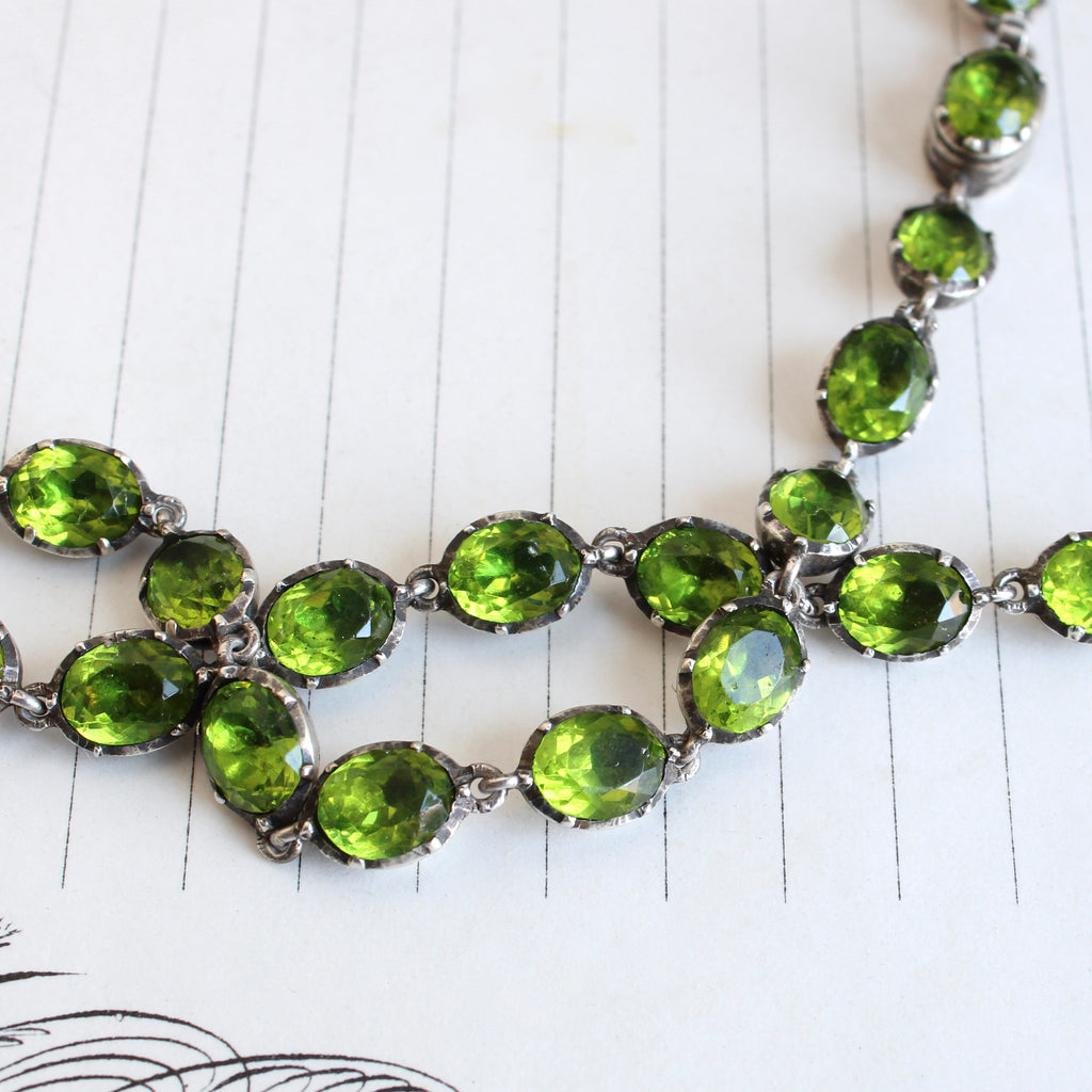 a continuous line necklace of rich peridot green opaste stones set in ribbed sterling bezels 