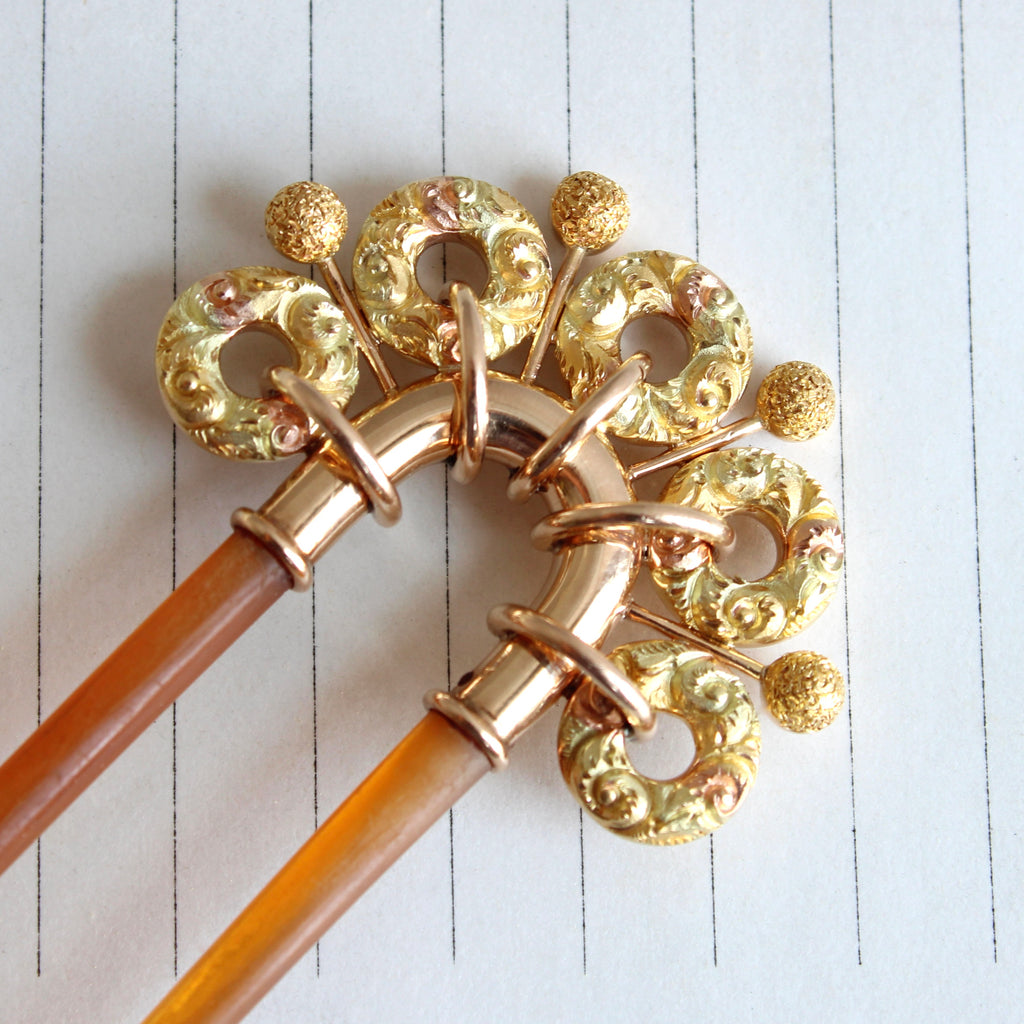 yellow and rose gold loops and balls top a tortoise shell two prong hair comb