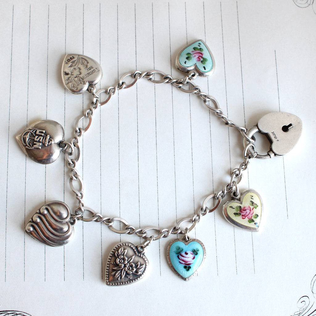 silver chain bracelet with seven puffy heart charms, some enameled with flowers