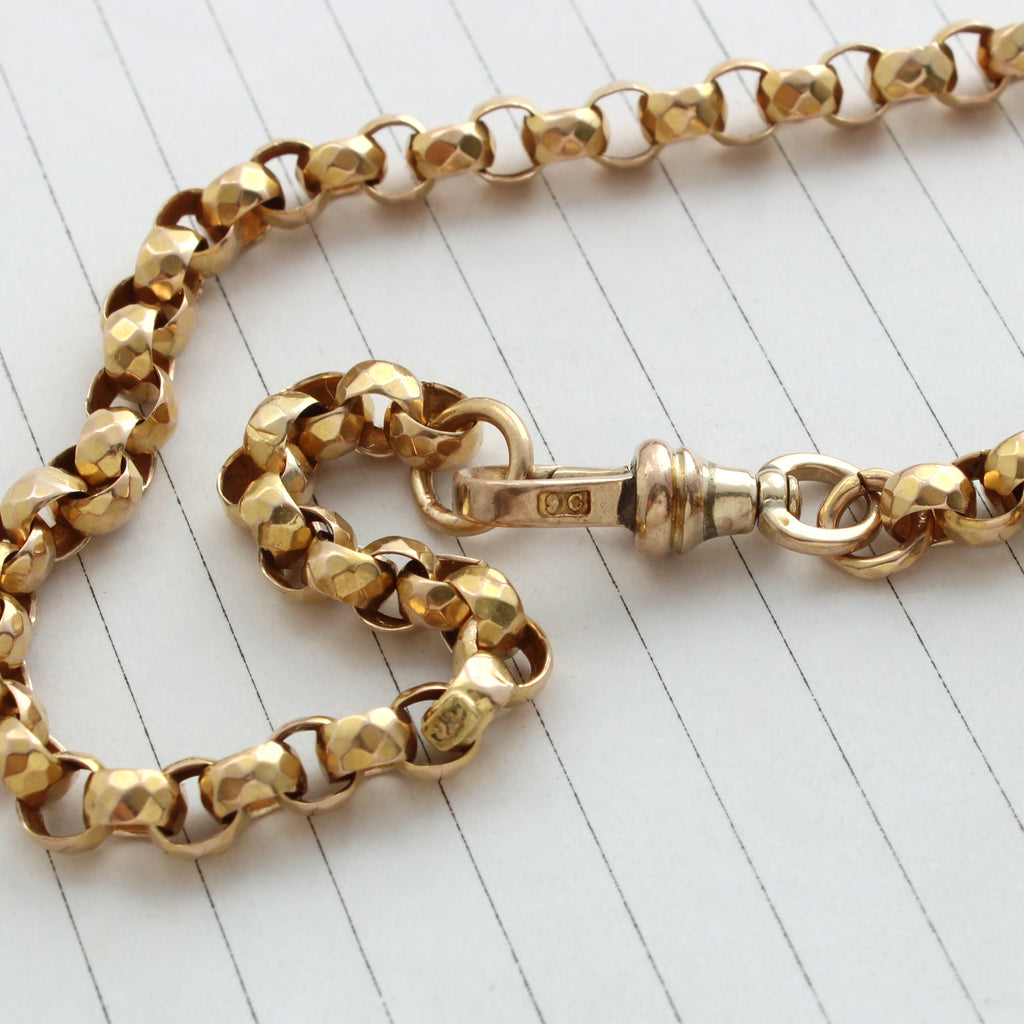 yellow gold chain with large round links that have been cut to look faceted 