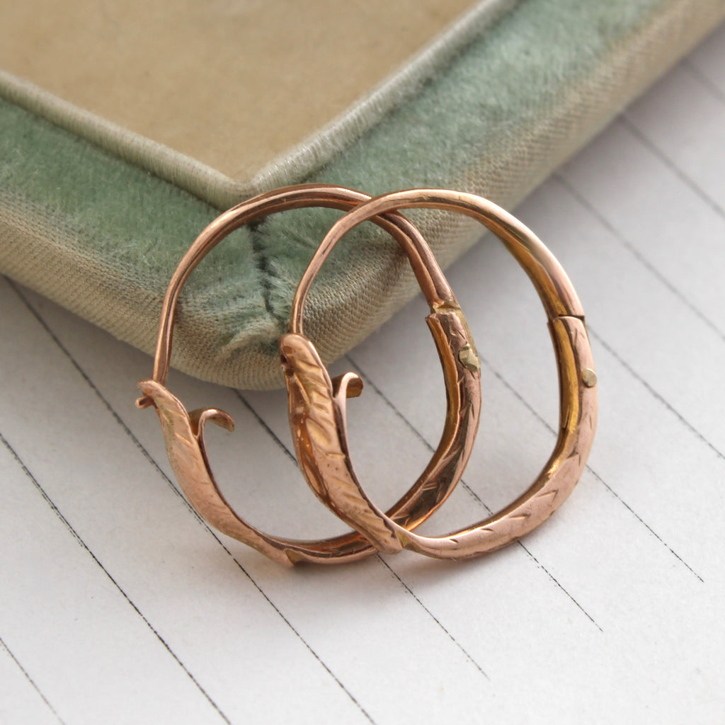 rose gold snake hoop earrings designed to look like a continuous loop where the snake eats its own tail