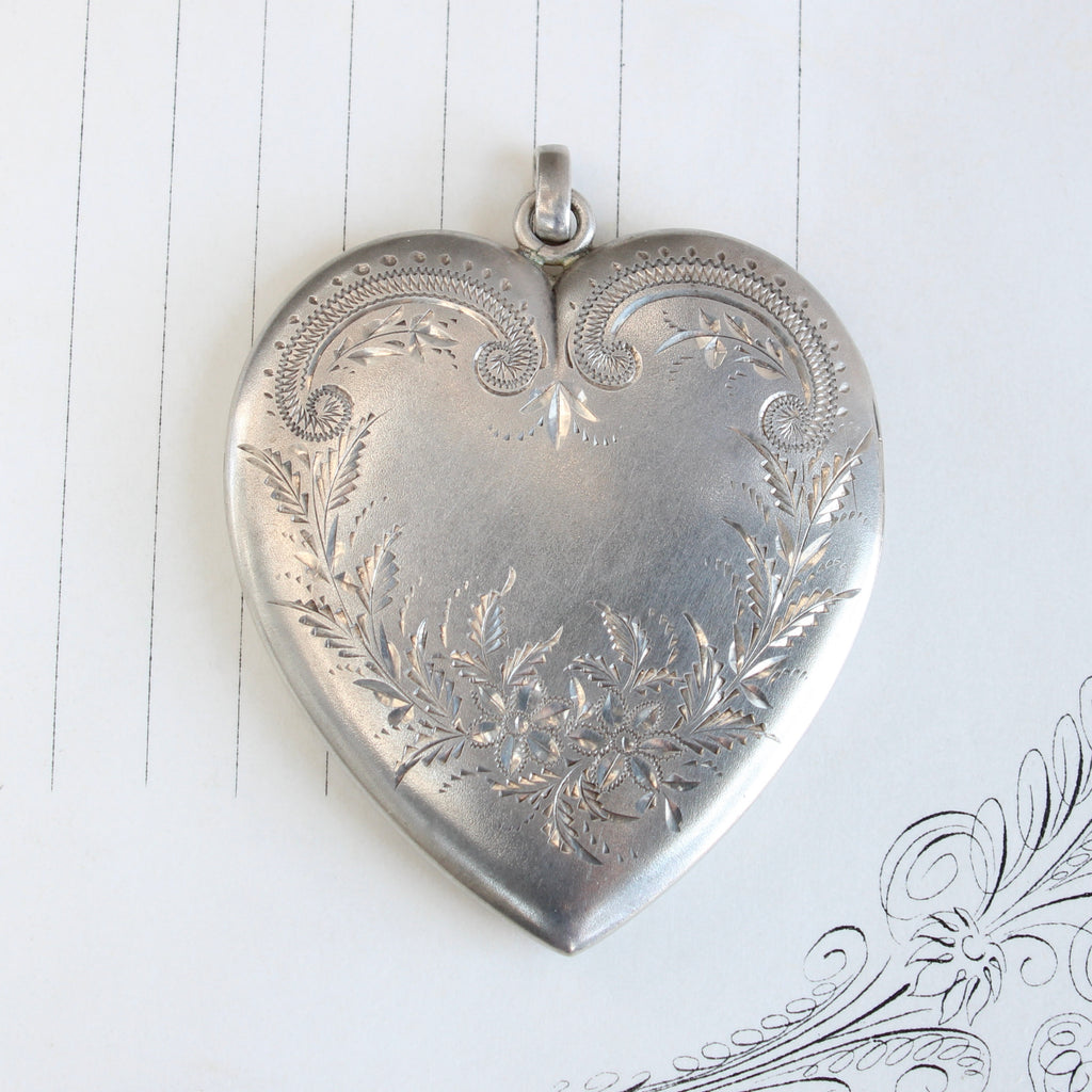  front cover of very large silver heart locket with engraved flowers 