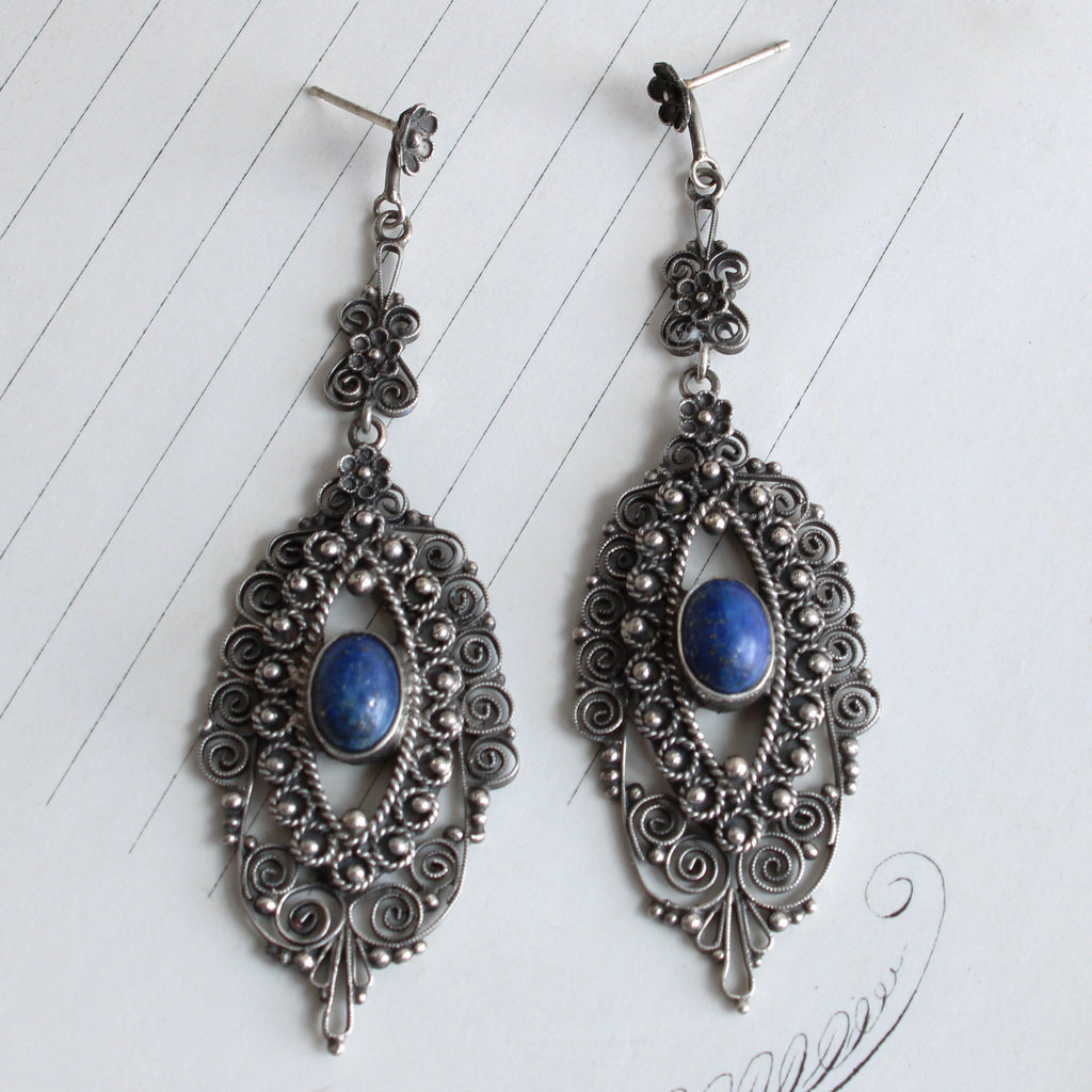 long silver filigree pendant earrings with posts and a lapis cabochon in the center of each pendant