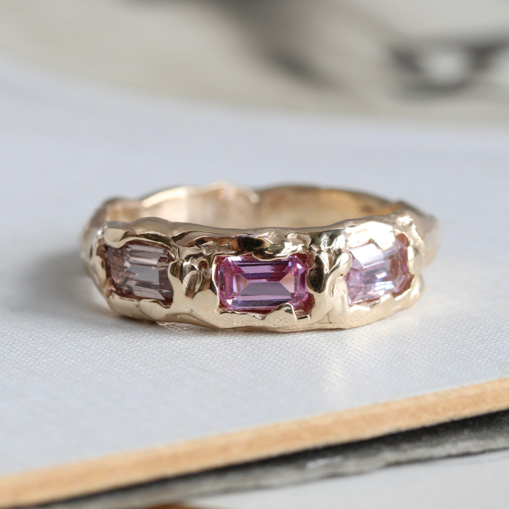 yellow gold ring in a branch style design with three baguette cut pink tourmaline across the front