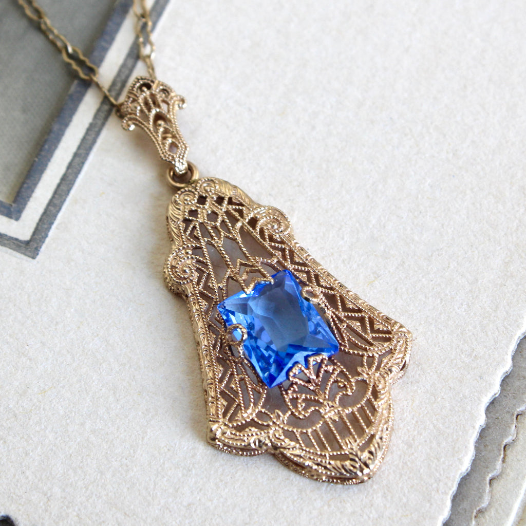 Antique yellow gold filigree pendant necklace with a rectangular blue glass stone.