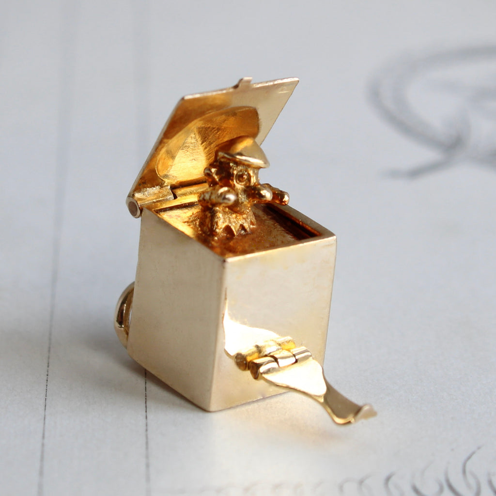 yellow gold box charm with a tiny clown inside that pops up when the lid is lifted