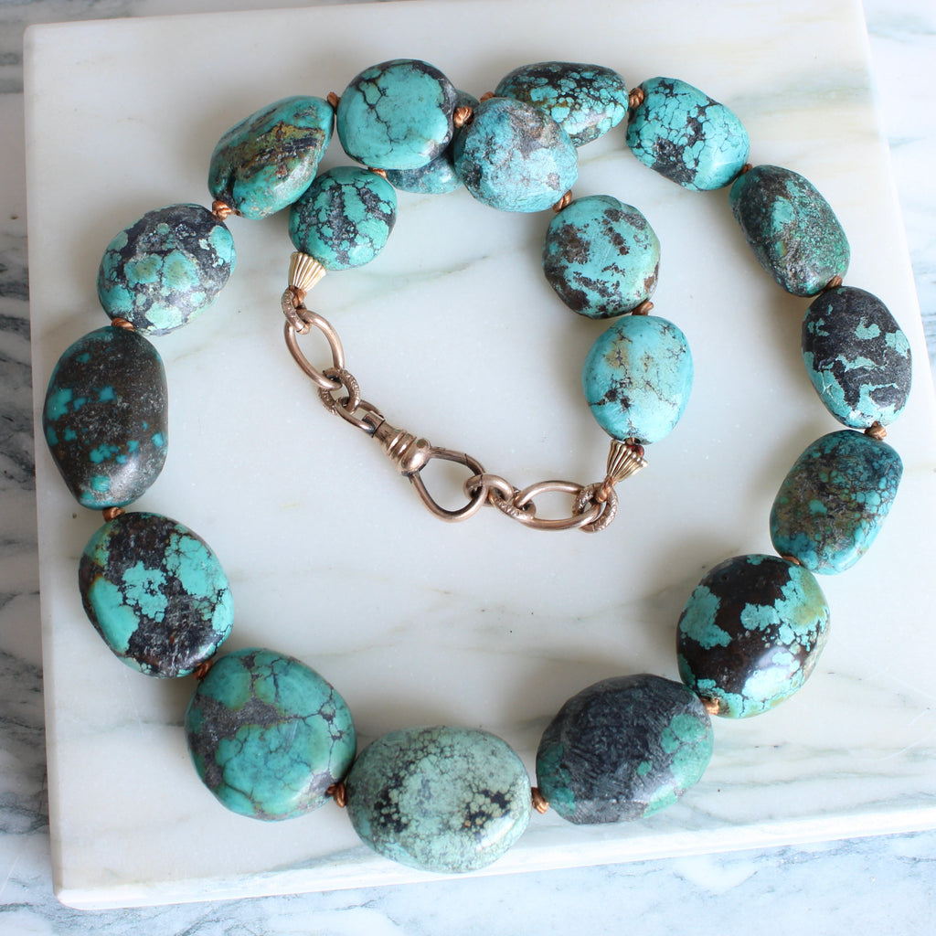 necklace of large irregular oval turquoise beads knotted on gold silk with an antique clip clasp