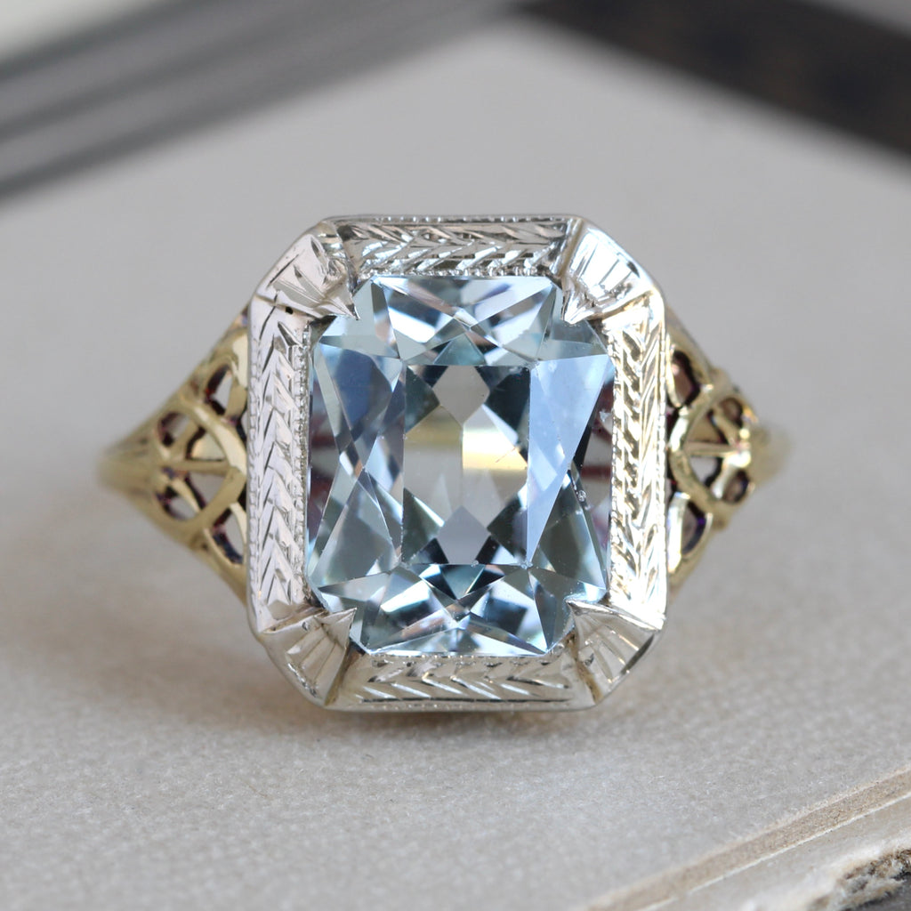 1930s yellow gold filigree ring with a faceted blue aquamarine in a white gold bezel