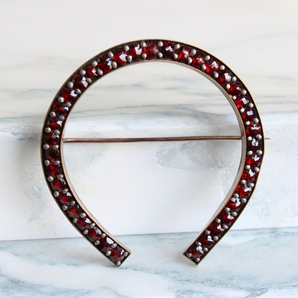 large horseshoe brooch set all around with rose cut garnets