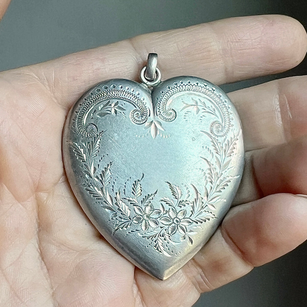 very large silver heart locket with engraved flowers on the front cover