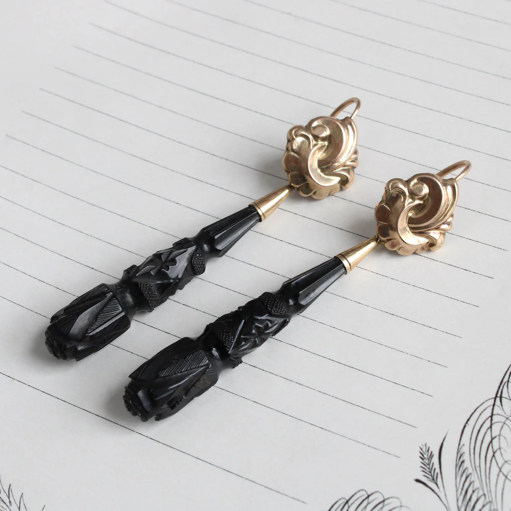 Antique earrings with fancy scroll motif gold tops and long tear drop carved black jet drops