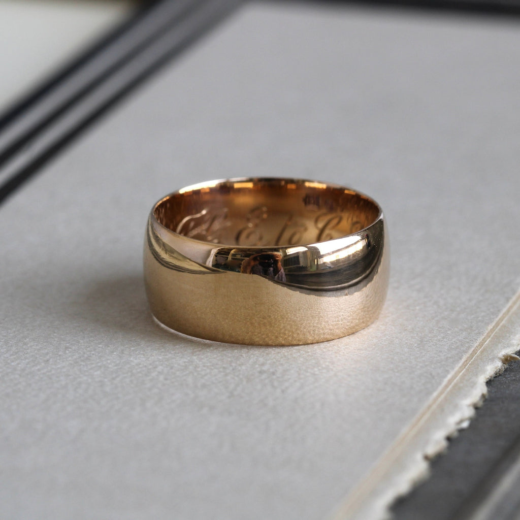 antique 18k yellow gold wide band ring with script engraving on the interior of the band.