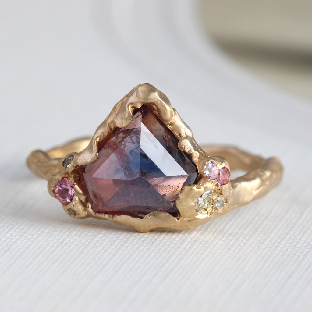 yellow gold branch style ring with a triangle shaped rose cut red and blue corundum accented by pink sapphires and diamonds