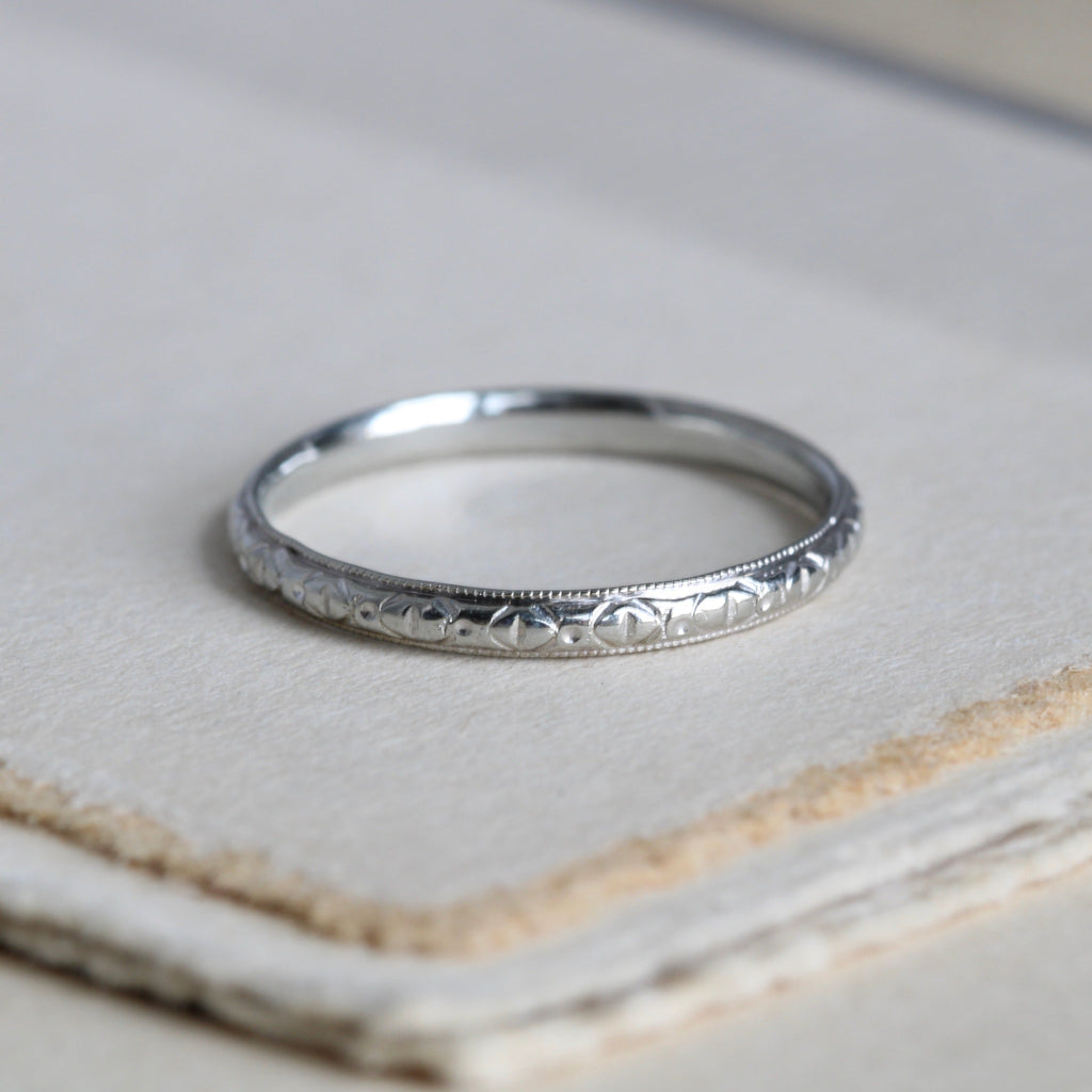 Vintage white gold art deco style wedding band ring with dainty engravings.