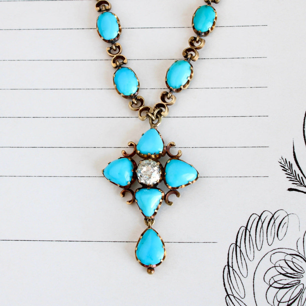 Antique yellow gold necklace with turquoise cabochons in a compass pattern around a sparkling diamond.
